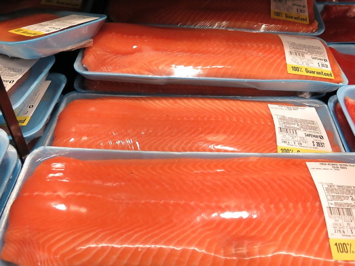 Three large packages of salmon, ribbon-like pinky orange and white throughout each 